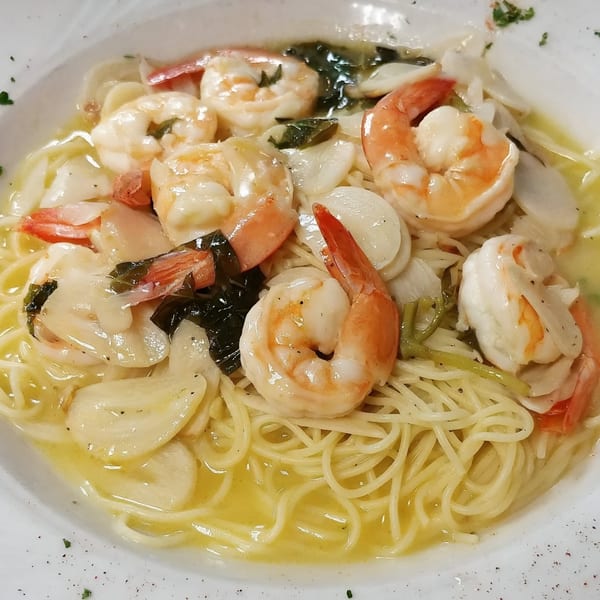 Mama Nina's shrimp scampi with spaghetti, garlic, and herbs in a white wine sauce.